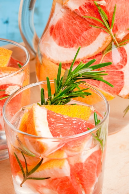 Refreshing summer detox cocktail of grapefruit and rosemary, on wooden rustic table, copy space, close view