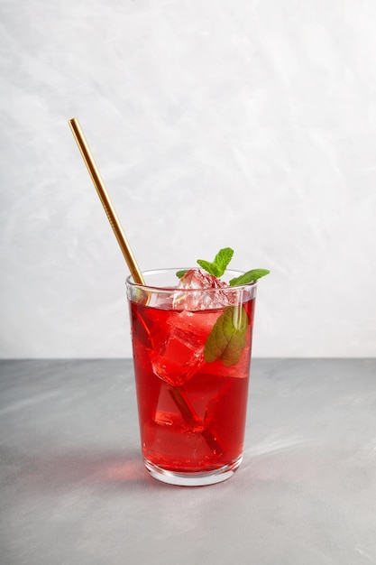 Refreshing summer drink Iced fruit tea or cold watermelon drink in clear tall glass with mint leaf