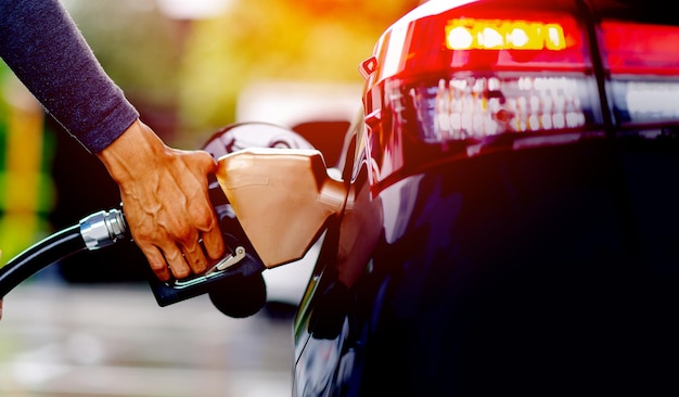 Refuel the fuel with the fuel nozzle Refuel the car at the gas station fill with gasoline The gas