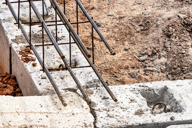 Reinforced concrete foundation of a modern monolithic residential building Prepared formwork with reinforcing mesh for pouring concrete Dirt and clay at the construction site