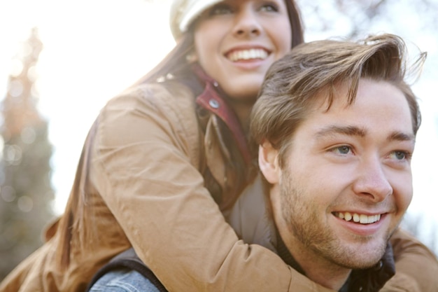 Photo relationship couple and smile in forest with piggyback for bonding support and trust in germany love people and happy in outdoor or woods for holiday sightseeing and adventure in winter