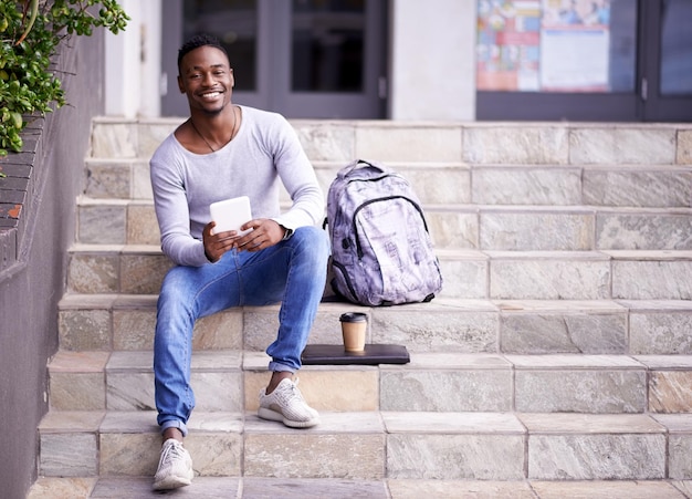 Relax college and tablet with portrait of black man for learning education or research Smile social media and technology with male student on stairs of university campus for app digital or study