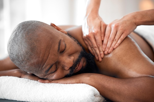 Relax man spa and back massage for luxury wellness therapy healing and skincare Therapist touch body muscle and reflexology of sleeping black man on salon bed stress relief and holistic detox