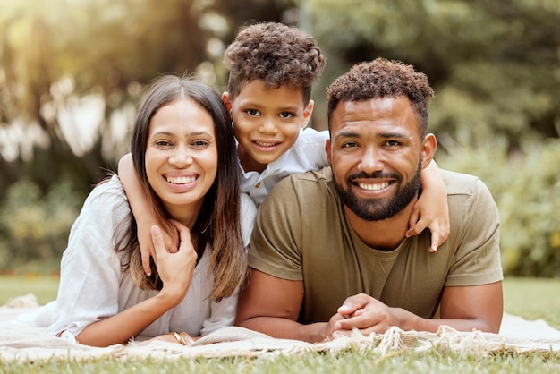 Relax picnic and happy with portrait of family in park for nature smile and summer together Spring growth and wellness with mother and father hug with child in grass field for peace and health