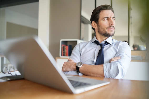 Relaxed attractive businessman working in modern office