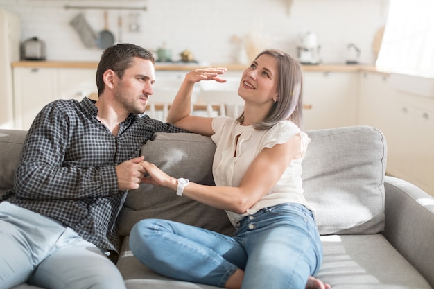 Relaxed casual couple talking  while sitting on sofa in apartment