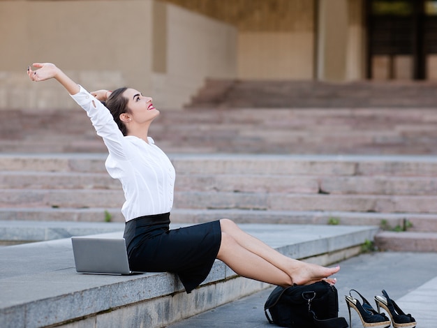 Relaxed content urban business woman outdoor working lifestyle