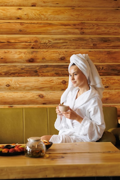 Relaxed girl drinking tea after sauna