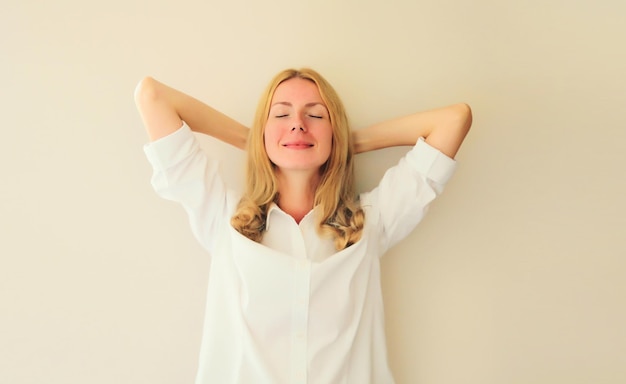 Relaxed happy young woman take a break meditates with closed eyes while working