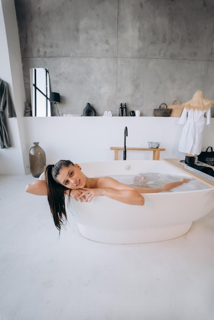 Relaxed lady taking bath enjoying and relaxing while lying in bathtub