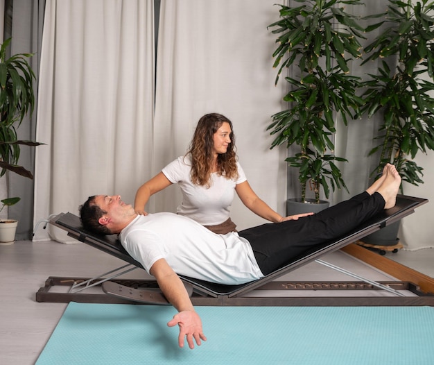 Relaxed man learning yoga poses with teacher