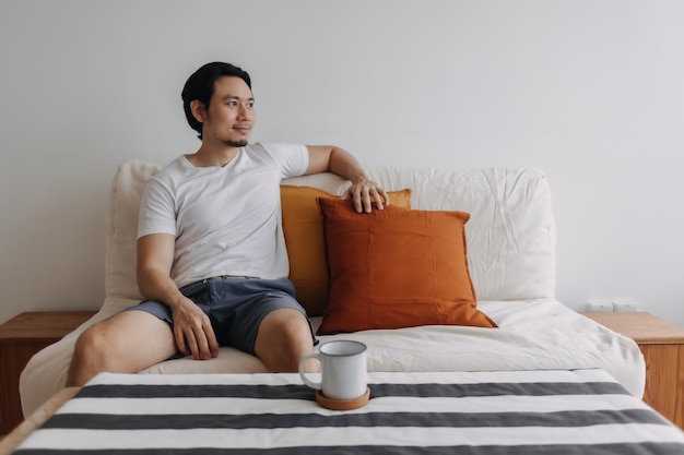 Relaxed man with coffee in the living room of the apartment