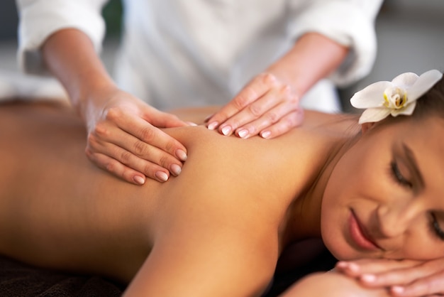 Relaxed smiling woman receiving a back massage in a spa