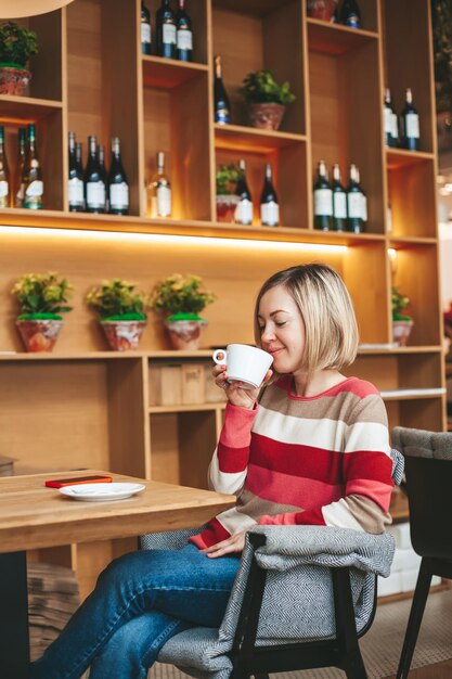 Relaxed woman drinking coffee in cafe