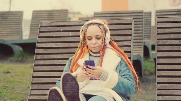 Relaxed woman listening to music on lounger in park