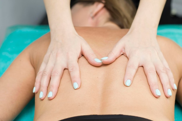 A relaxed woman receiving a back massage at a wellness center