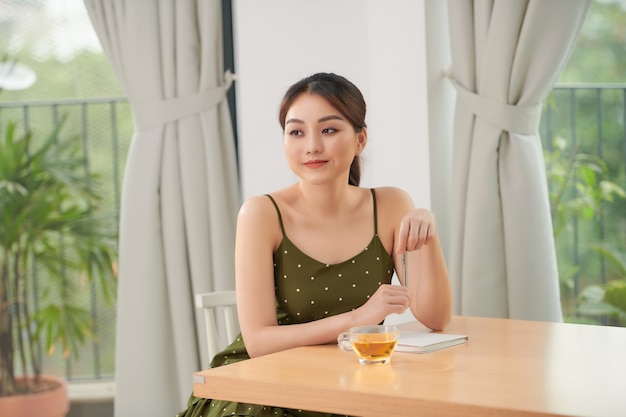 Relaxed young woman near big window at home