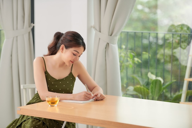 Relaxed young woman near big window at home