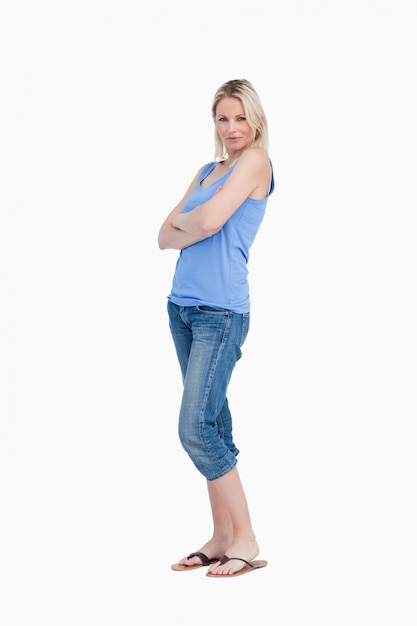 Photo relaxed young woman standing upright with arms crossed