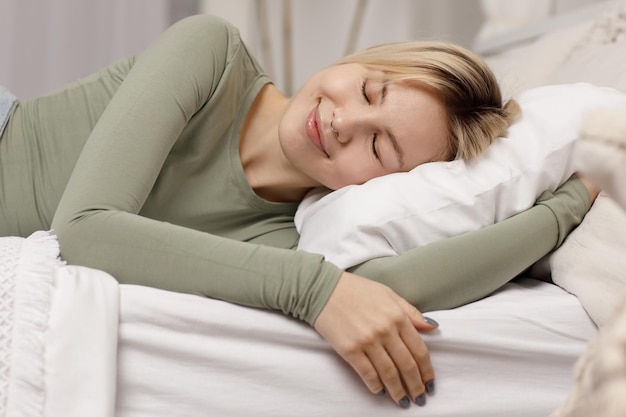 Relaxing smiling girl lying on pillow bed Healthy sleep