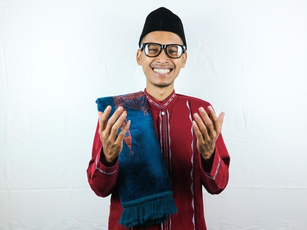 Religious asian muslim man in traditional dress using prayer beads isolated on white background