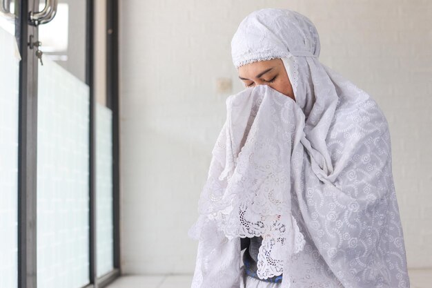 Religious islamic background of muslim prayer woman covering face with her hands make dua praying