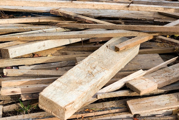 Remains of planks with nails after the installation of concrete formwork Recycling of lumber Background from scraps of old boards