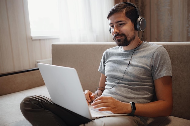 Remote Job Man Working On Laptop Sitting On Sofa At Home