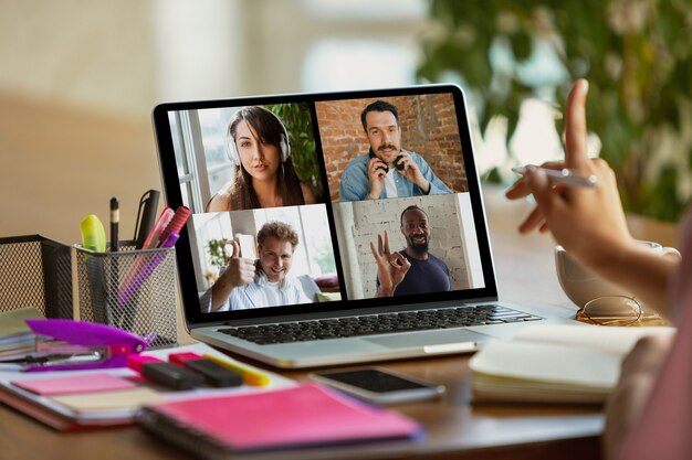 Remote meeting. Woman working from home during coronavirus or COVID-19 quarantine, remote office concept. Young boss, manager in front of monitor during online conference with colleagues and team.