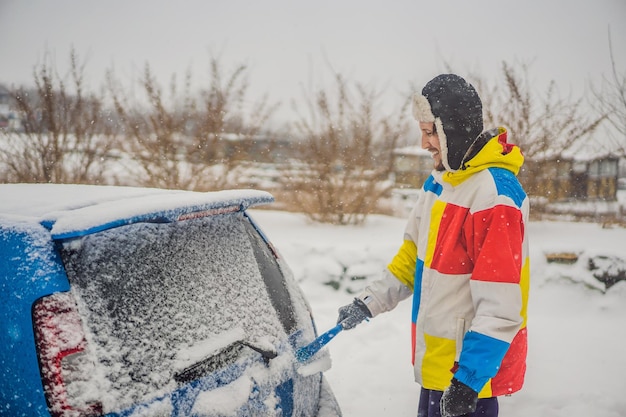 Removing snow from car with a brush