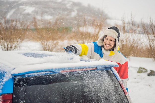 Removing snow from car with a brush