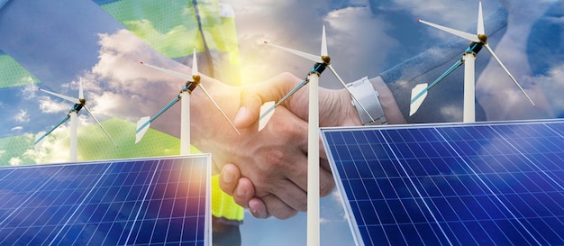 Renewable green energy is friendly industry Business partners shaking hands in field with solar panels