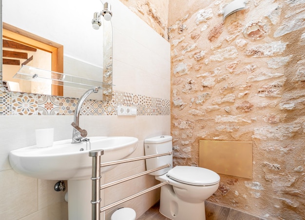 Renovated modern bathroom with vintage tiles and stone walls