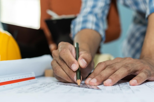 Renovation. interior designer planning and working on blueprint on desk in meeting room office at construction site, contractor, architecture, construction teamwork, industrial, engineering concept