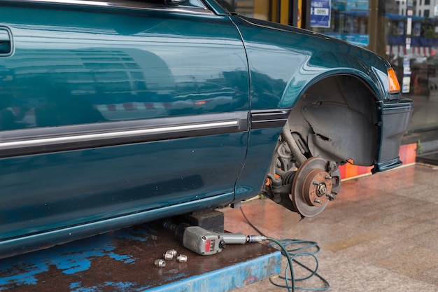 Repairing a wheel of car on lift elevator in garage