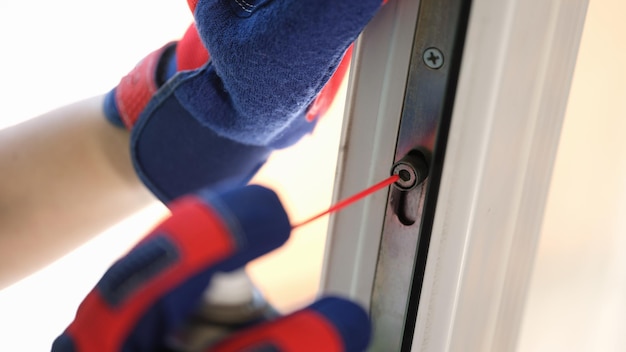 Repairman fixes window closing problem handyman in gloves serves windows of customers close up