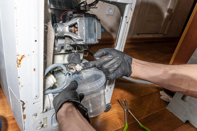 A repairman repairs a used washing machine