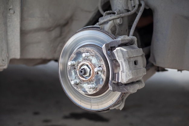 Replacement of brake pads Car brake repairing in garage Suspension of car for maintenance brakes