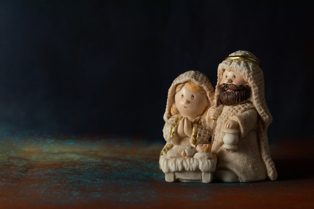 Representation of a Christmas nativity scene with the small figures of baby Jesus, Mary and Joseph on a rock background.