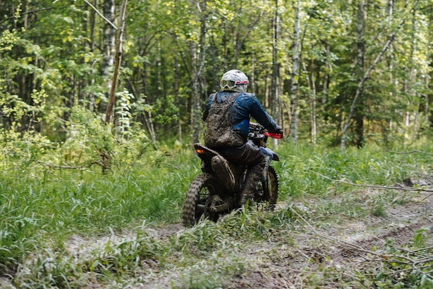 REPUBLIC OF KARELIA RUSSIA CIRCA JUNE 2022 Offroad tournament Ladoga Trophy 2022 in Karelia Motorcycle racer in dirt on sports motorcycle rides through muddy puddles