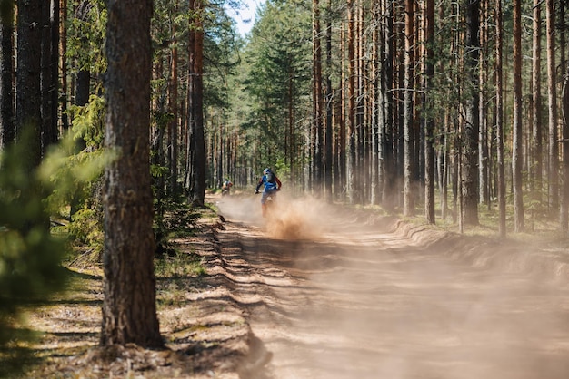 REPUBLIC OF KARELIA RUSSIA CIRCA JUNE 2022 Offroad tournament Ladoga Trophy 2022 in Karelia Motorcycle racers on sports enduro motorcycles ride along a dusty road in forest