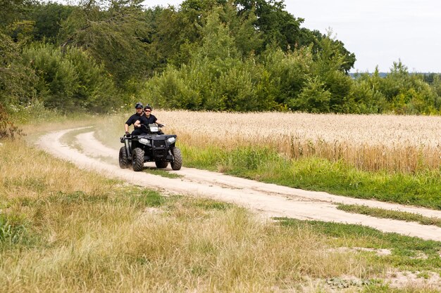 Photo the rescuer a beautiful athletic physique rides an atv in the middle of the field