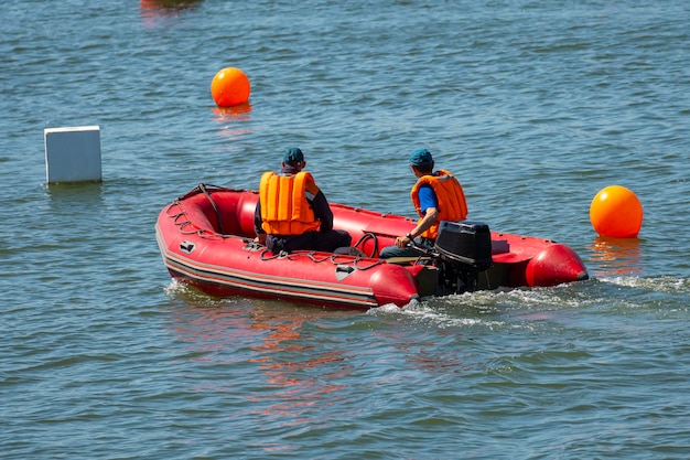 Rescuers on a red inflatable boat patrol sea