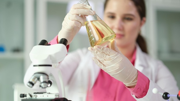 Researcher scientist student holding flask with yellow liquid