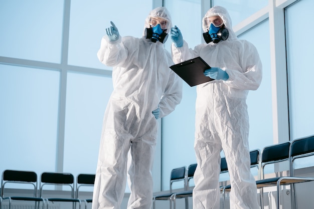 Researchers in protective suits discussing current tasks