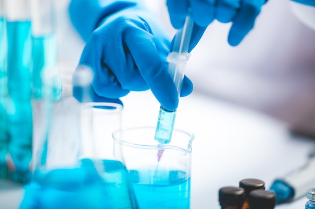 Researchers scientist working analysis with blue liquid test tube in the laboratory, chemistry science or medical biology experiment technology, pharmacy development solution