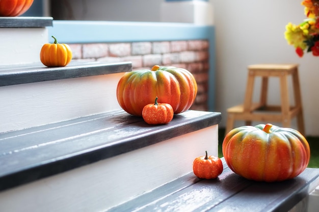 Residential house decorated for Halloween holiday colored pumpkins in front door On Wooden Steps