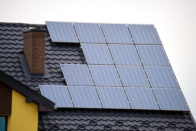 Residential house with rooftop covered with solar photovoltaic panels for producing of clean ecological electrical energy in suburban rural area Concept of autonomous home