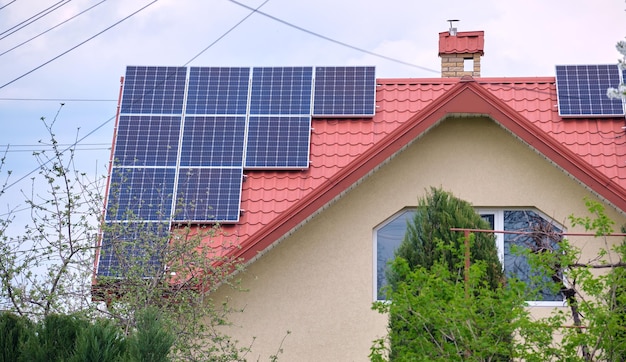 Residential house with rooftop covered with solar photovoltaic panels for producing of clean ecological electrical energy in suburban rural area Concept of autonomous home