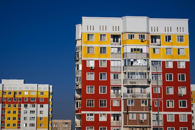 Residential new houses with windows and balconies on sky background